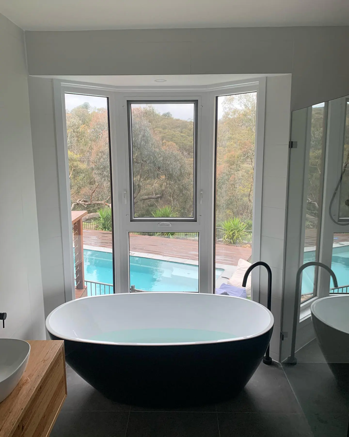 Renovated bathroom in a Deakin home with a tiled shower, floating vanity and round mirror