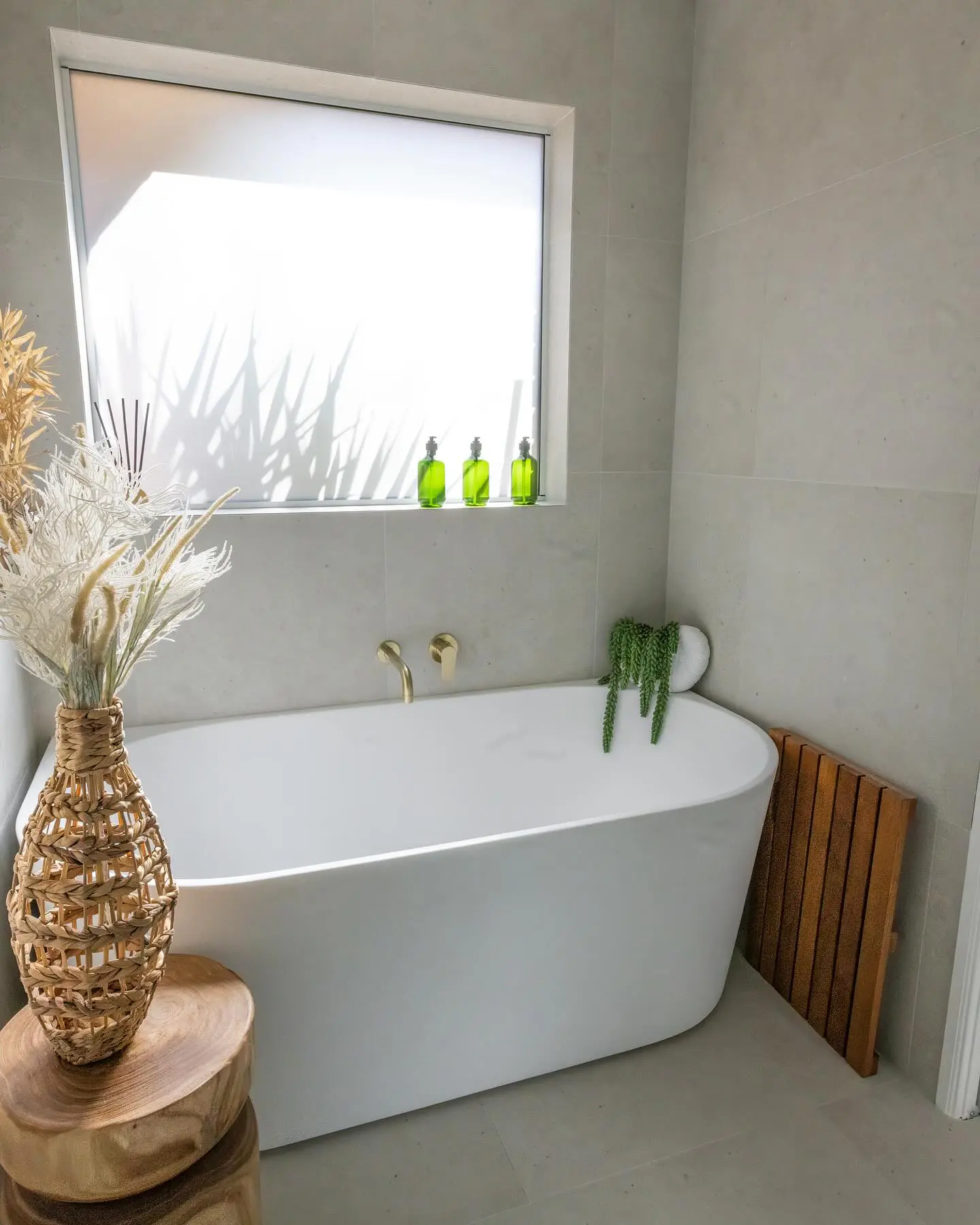 Renovated bathroom in a Forrest home with floor to ceiling tiles, a bath and timber cabinetry